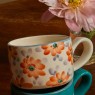 Tazza da cappuccino in ceramica con fiori arancioni dipinti a